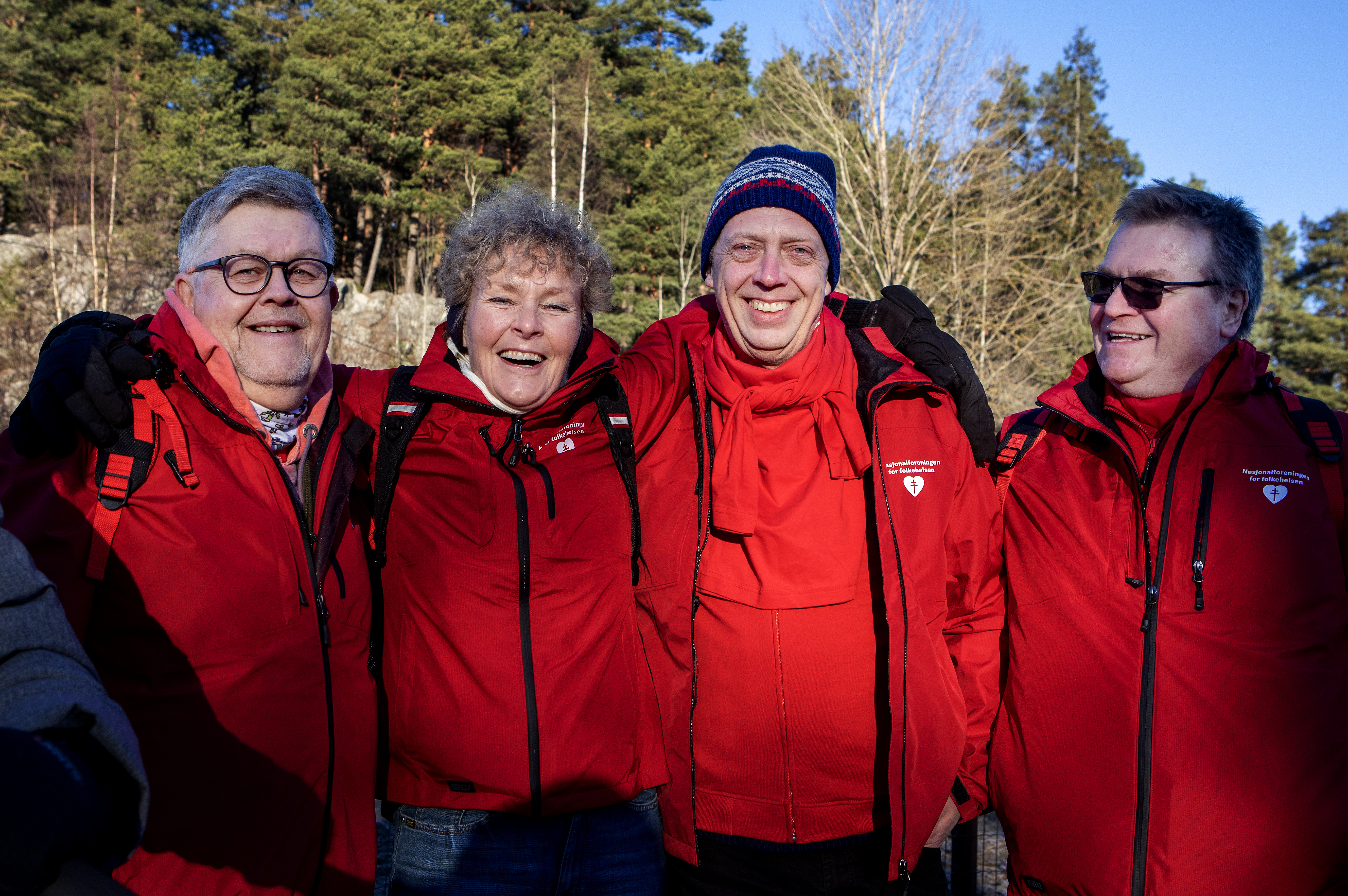 Bilde av smilende folk som holder rundt hverandre på en gåtur